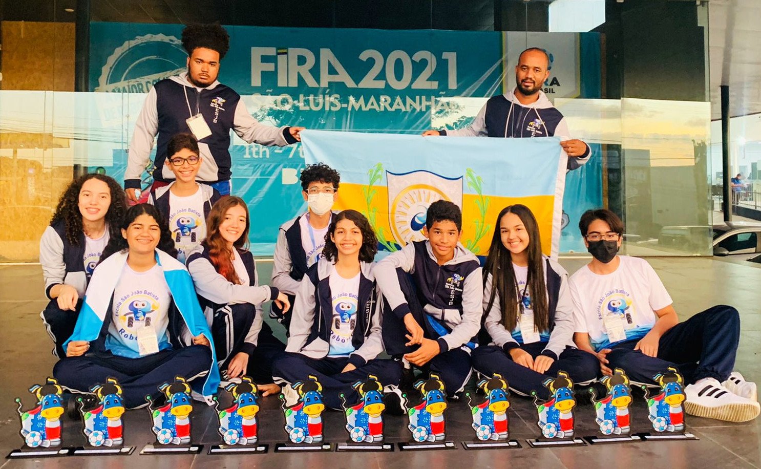 Alunos e professores de robótica com troféus Alunos e professores de robótica com troféus